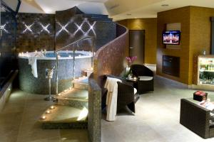 a bathroom with a tub and a sink in a room at Hotel Turiec in Martin