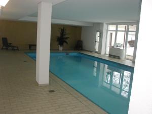 een groot blauw zwembad in een gebouw bij 1Z. FeWo 231 barbo Schwimmbad-Sauna-Fitness in Schönwald