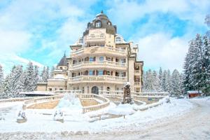 un gran edificio cubierto de nieve frente a los árboles en Festa Winter Palace Hotel, en Borovets