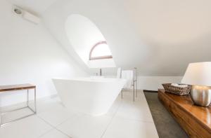 a white bathroom with a tub and a table at Hotel Jakubus in Wilków +141 photos
