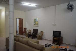 a living room with a couch and a tv at RILEK-RILEK HOMESTAY in Jertih