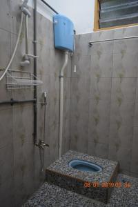 ein Bad mit einem WC in einer gefliesten Wand in der Unterkunft RILEK-RILEK HOMESTAY in Jertih