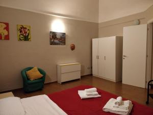 een slaapkamer met een bed, een stoel en handdoeken bij Due di Coppa in Scafati