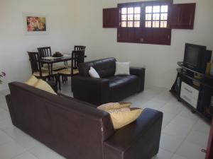 a living room with a couch and a tv at Casa Praia de Tamandaré PE in Tamandaré