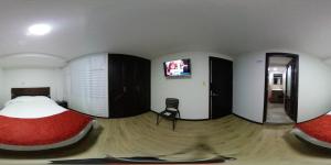 a bedroom with two beds and a flat screen tv at Hotel Florida ApartaSuites. in Ipiales