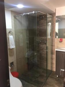 een badkamer met een glazen douche, een toilet en een wastafel bij Hotel Florida ApartaSuites. in Ipiales