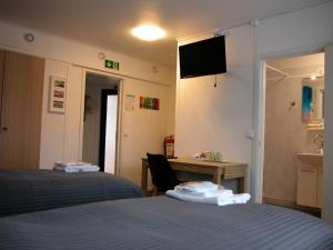 Cette chambre comprend deux lits et un bureau. dans l'établissement Cafè Bistro Moccacino, à Ekshärad