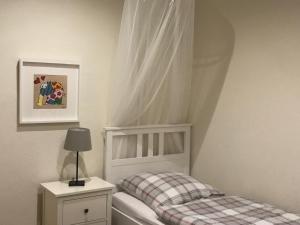 a childs bedroom with a white bed and a lamp at Schlafen & Wohlfühlen in Bremerhaven