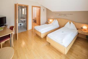Un pat sau paturi într-o cameră la Gasthaus Pension Zum lustigen Steirer