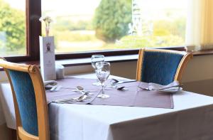 a table with two wine glasses on top of it at Bowood Park Hotel in Camelford