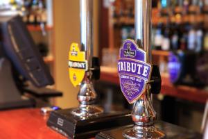 a bar with two metal posts with the words indulge at Bowood Park Hotel in Camelford