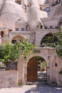 an old building with a wooden door and an archway at Village Cave House Hotel in Göreme