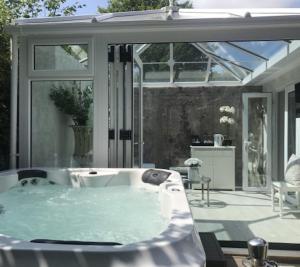 a jacuzzi tub in a room with a patio at Who'd A Thought It in Lenham