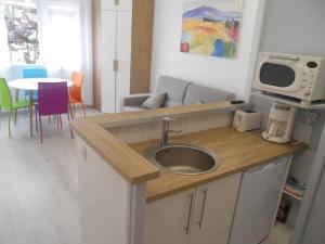 a kitchen with a sink and a table with chairs at La Forêt 5 in Mimizan-Plage