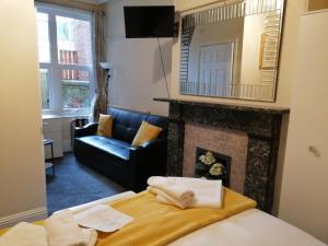 a living room with a bed and a fireplace at Gillygate Guest House in York