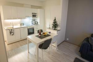a white kitchen with a table and a christmas tree in it at Rollo Apartments in Rovaniemi