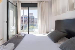 バルセロナにある1214 - TWO BEDROOMS CIUTADELLA APARTMENTのベッドルーム(大きな白いベッド1台、大きな窓付)