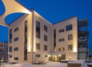 un condominio nella neve di notte di Rollo Apartments a Rovaniemi