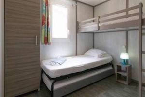 a small bedroom with a bunk bed and a window at Farniente en Martinique in Le Vauclin