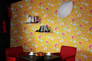 uma sala de jantar com uma parede amarela com flores em Camping l'Ile aux Oiseaux em LʼÎle-dʼOlonne