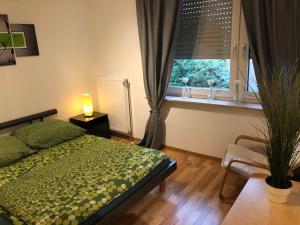 a bedroom with a bed and a window with a plant at Apartment Essen Holsterhausen in Essen