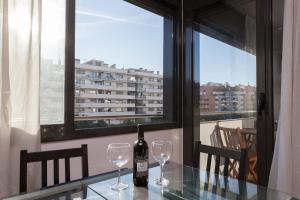 a bottle of wine sitting on a glass table with two glasses at 1217 - POOL AND BEACH NICE APARTMENT II in Barcelona
