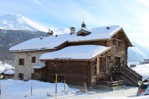 een blokhut met sneeuw op het dak bij Chalet Mistral in Livigno