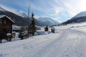 een weg bedekt met sneeuw naast een huis bij Chalet Mistral in Livigno