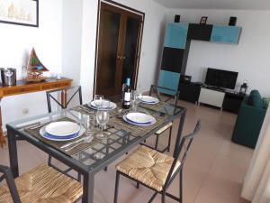 una mesa de comedor con platos y vasos. en Apartment La Rosa (Blaumar), en Sant Andreu de Llavaneres