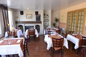 un ristorante con tavoli, sedie e un camino di The Originals City, Hôtel Le Cheval Rouge, Tours Ouest (Inter-Hotel) a Villandry