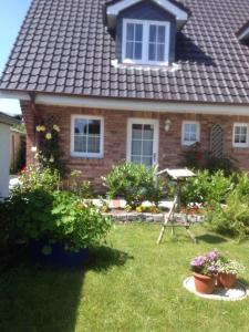 une maison avec quelques plantes dans la cour dans l'établissement Mittelreihenhaus Carla - Sylt, Westerland, à Tinnum