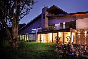 a large house with a tree in front of it at Hotel Bystrá in Brezno