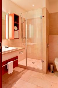 a bathroom with a shower and a toilet and a sink at Hotel Navigare Buxtehude in Buxtehude +73 photos