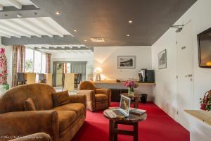 ein Wohnzimmer mit einem Sofa und einem Tisch in der Unterkunft Hôtel Chez Pierre d'Agos in Agos-Vidalos