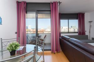 Una sala de estar con un sofá y una mesa de cristal. en 1216 - Forum Gardens Apartment, en Barcelona