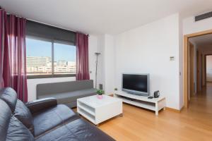 Una sala de estar con un sofá y un televisor. en 1216 - Forum Gardens Apartment, en Barcelona