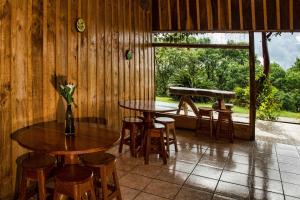 Cabinas Capulin & Farm في مونتيفيردي كوستاريكا: غرفة بطاولتين وكراسي ونافذة