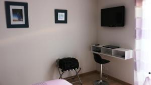 a room with a bed and a tv on the wall at Chez Victoria Nantes Erdre in Nantes