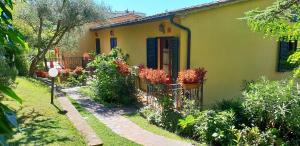 a yellow house with a garden in front of it at Residence Villa Elena in Guardistallo
