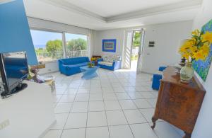 un soggiorno con divano blu e TV di Villa Trinacria Apartments ad Alcamo Marina