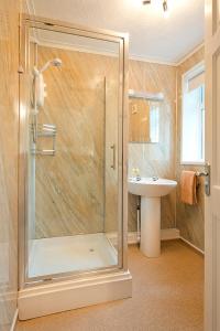 a bathroom with a shower and a sink at Trelawne Manor Holiday Park in Looe