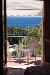 two chairs sitting on a balcony looking out at the ocean at Hotel Rosa Del Tirreno in Quercianella