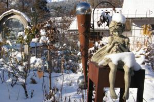 a statue of a girl sitting in a chair in the snow at Thalerhof in Roppen