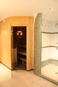 a bathroom with a shower and a glass door at Vitalhotel Sonnblick in Egg am Faaker See