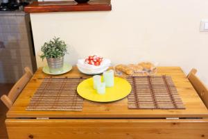 drewniany stół z dwoma talerzami jedzenia w obiekcie Sunny Home w Rzymie