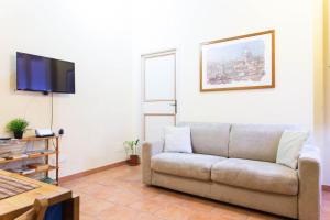 salon z kanapą i telewizorem z płaskim ekranem w obiekcie Sunny Home w Rzymie