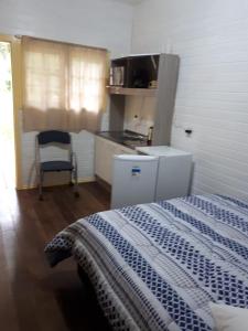 a small kitchen with a bed in a room at Chalé da Tranquilidade in Gramado