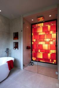 La salle de bains est pourvue d'une baignoire et d'un mur en verre. dans l'établissement TERRE DE REVE, à Le Rouret