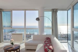 a living room with a white couch and large windows at 1410 - Mediterranean Forum Apartment in Barcelona