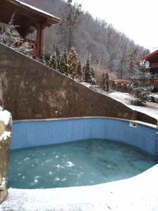 a large pool of water with a stone wall at Guesthouse Lyubava in Kamennomostskiy